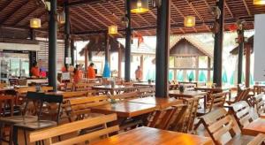 an empty restaurant with wooden tables and chairs at Jirawan Hotel in Ko Samed