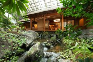 a building with a waterfall in front of a house at Gajoen Tokyo in Tokyo