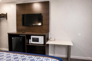 a room with a microwave and a table and a tv at Masters Inn Augusta at Washington Road in Augusta