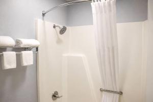 a shower with a white shower curtain in a bathroom at Masters Inn Augusta at Washington Road in Augusta +41 photos