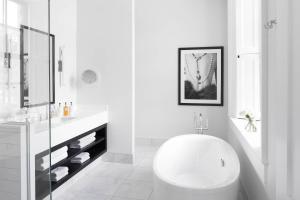 a white bathroom with a toilet and a sink at Frontenac Club, an Ascend Collection Hotel in Kingston +30 photos