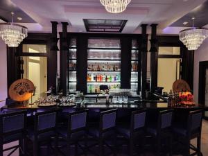 a bar in a restaurant with chairs and chandeliers at Frontenac Club, an Ascend Collection Hotel in Kingston