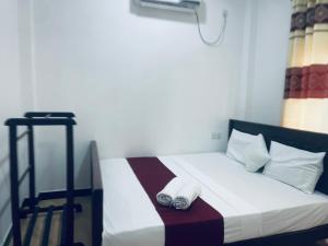 a bedroom with a bed with two towels on it at Nilaveli Beach Haven in Nilaveli
