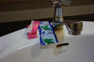 a sink with a tube of toothpaste and tooth paste on it at Lankham Hotel in Pakse