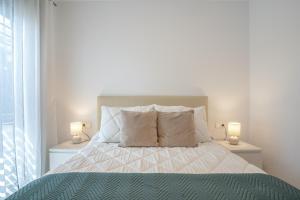 a bedroom with a bed with two lamps on both sides at Adhara lll in Torre del Mar +20 photos
