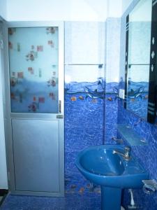 a bathroom with a blue sink and a shower at Nilaveli Beach Haven in Nilaveli +26 photos