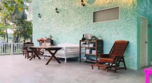 a room with a table and chairs and a green wall at Charisma Resort in Suan Phung