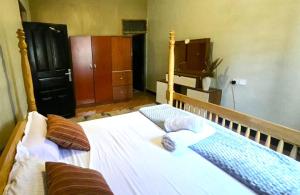 a bedroom with a bed with two pillows on it at Roadhouse in Jinja