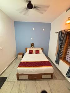 a bedroom with a bed with a ceiling fan at Zak Holidays Wayanad in Wayanad +4 photos