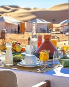 a table with a plate of food and bottles and glasses at Bhbs accommodatie Maroc2 in Tazzarine