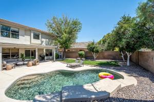 a swimming pool in a yard with a house at Dos Palmas - Gilbert Poolside Retreat in Gilbert