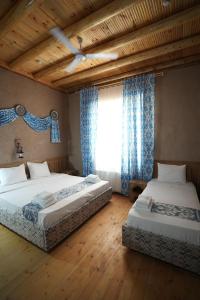 a bedroom with two beds and a window at Arda Angariki in Khiva +149 photos