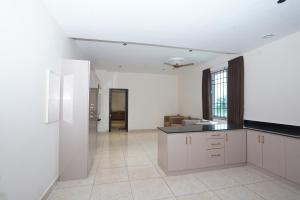 a kitchen with white cabinets and a counter top at Shree Priyam Residency in Rāmanāthapuram