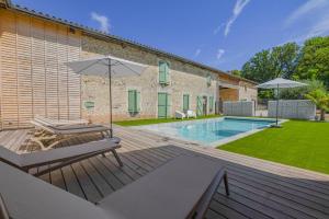 a backyard with a swimming pool and an umbrella at Le château de crespy in Crespy-le-Neuf