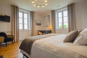 a bedroom with a large bed and two windows at Le château de crespy in Crespy-le-Neuf