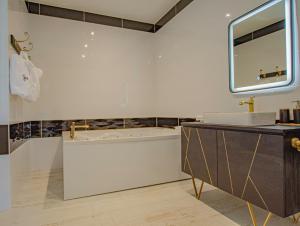 a white bathroom with a tub and a sink at Le château de crespy in Crespy-le-Neuf