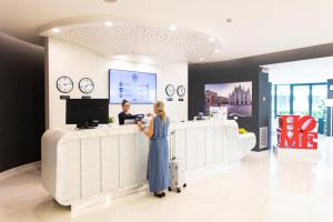 a woman standing at a cash register in a store at AN Hotel Milano Melegnano in Carpiano
