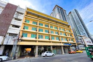 a yellow building with cars parked in front of it at Hotel Uno in Davao City