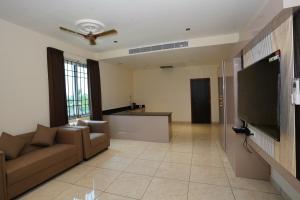 a living room with a couch and a flat screen tv at Shree Priyam Residency in Rāmanāthapuram