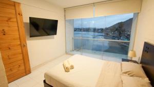 a bedroom with a bed and a large window at Nutria Apt in Cerro Azul with access & ocean view in Cerro Azul +14 photos
