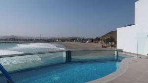 a swimming pool with a view of a body of water at Nutria Apt in Cerro Azul with access & ocean view in Cerro Azul