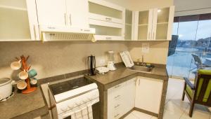 a kitchen with white cabinets and a sink at Nutria Apt in Cerro Azul with access & ocean view in Cerro Azul