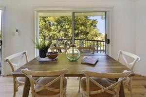 a dining room table with chairs and a window at Advance Place in Sunrise Beach