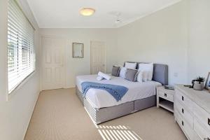 a white bedroom with a bed and a window at Advance Place in Sunrise Beach