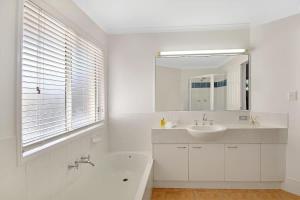 a white bathroom with a sink and a mirror at Advance Place in Sunrise Beach +3 photos