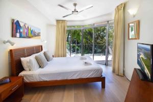 a bedroom with a bed and a large window at Park Cove Apartments in Noosa Heads