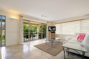 a living room with a white couch and a table at Alderly Terrace in Noosa Heads