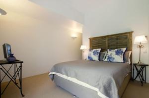 a bedroom with a large bed with blue pillows at Alderly Terrace in Noosa Heads