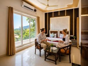 a man and woman sitting on a couch in a living room at Mountain View Retreat in Yog Tapovan in Rishīkesh