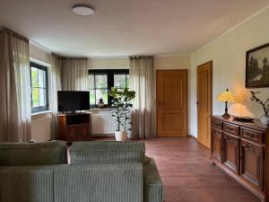 a living room with a couch and a tv at Ferienhaus Eichenallee in Massow