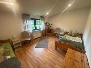 a room with two beds and a table and chairs at Ferienhaus Eichenallee in Massow