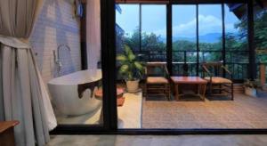 a bathroom with a tub and a table and chairs at Cocoa Valley Resort in Pua +242 photos