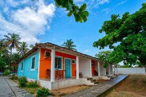 a small house with an orange and blue at Baga Wave Edge Cottages in Baga +13 photos