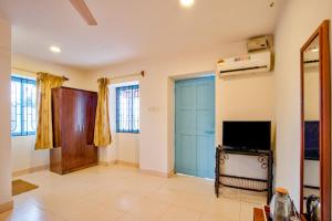 a living room with a blue door and a tv at Baga Wave Edge Cottages in Baga