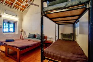 a bedroom with two bunk beds in a room at Baga Wave Edge Cottages in Baga