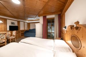 a bedroom with a bed and a blue couch at EL CIASEL in Canazei