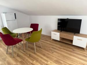 a living room with a table and chairs and a television at Păușa Residence in Păuşa +3 photos