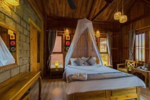 a bedroom with a bed with a mosquito net at Vang Vieng KT Resort in Vang Vieng