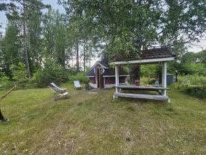 a picnic table and a gazebo in a yard at Rönnypiha  +9 photos