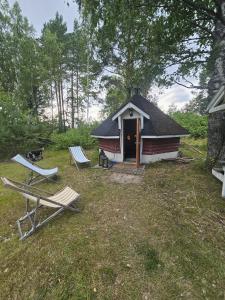 a cabin with two chairs and a bench in front of it at Rönnypiha 
