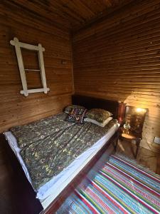 a bed in a wooden room with a ladder at Rönnypiha 