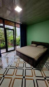 a bedroom with a bed and a green wall at Горный уют in Burchmulla
