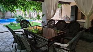 a dining table and chairs on a patio at Горный уют in Burchmulla