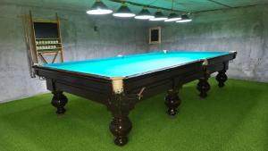 a pool table in a room with green carpet at Горный уют in Burchmulla +2 photos