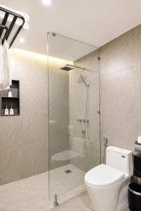 a bathroom with a toilet and a glass shower at Y Hotel Lý Hồng Thanh in Can Tho +57 photos