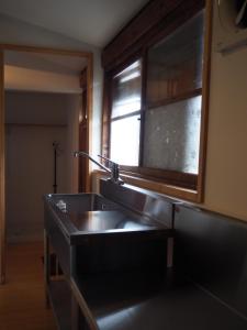 a kitchen with a sink and a window at うみうたう in Yuwan